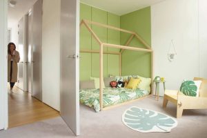 A child's bedroom with pea-green feature wall