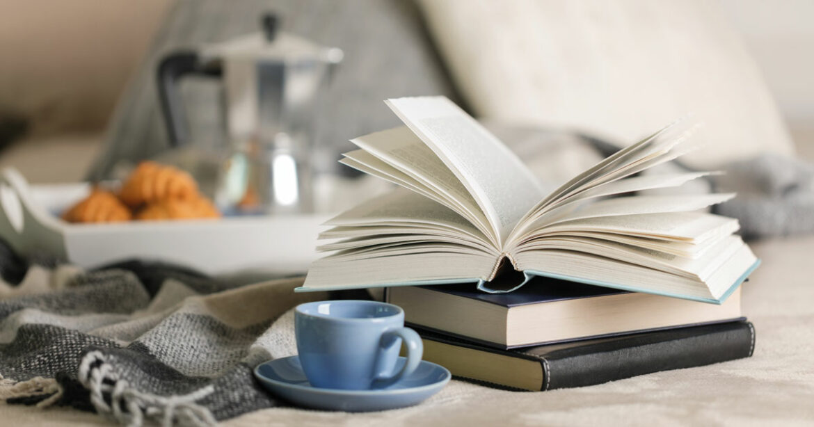 Open book on a table with an espresso cup