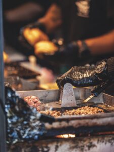 A black latex hand prepares food