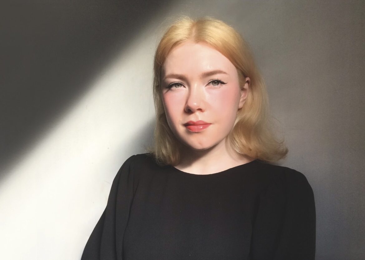 A blonde girl wearing a black top