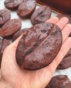 A giant coffee bean held in the palm of a hand