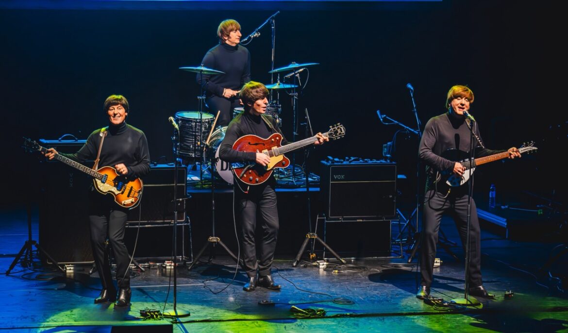 A band of four musicians playing instruments on stage