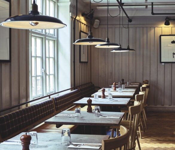 A row of tables at a restaurant with hanging lights above