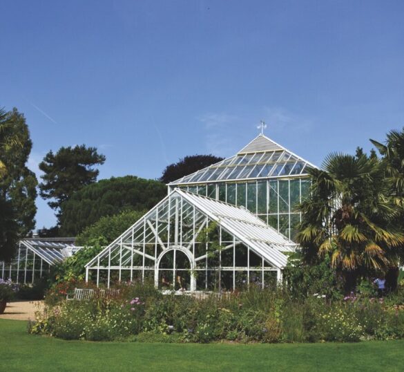 A large greenhouse surrounded by grass and trees