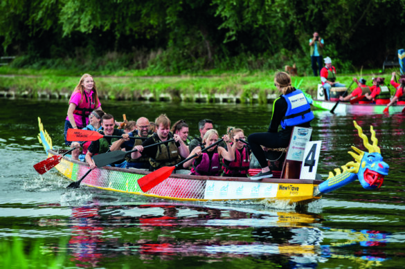 A team of rowers on a dragon boat journeying down a river