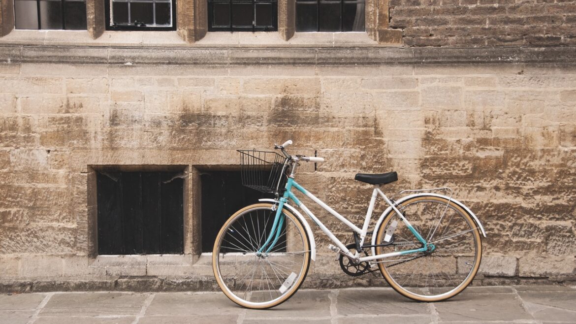 A blue bike leaning against a stone wall