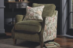 An green floral armchair in a dimly lit room