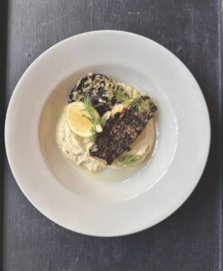 Top view of a savoury dish with lemon, fish and a sauce