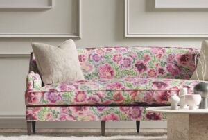 a floral print sofa in a beige room with a coffee table nearby