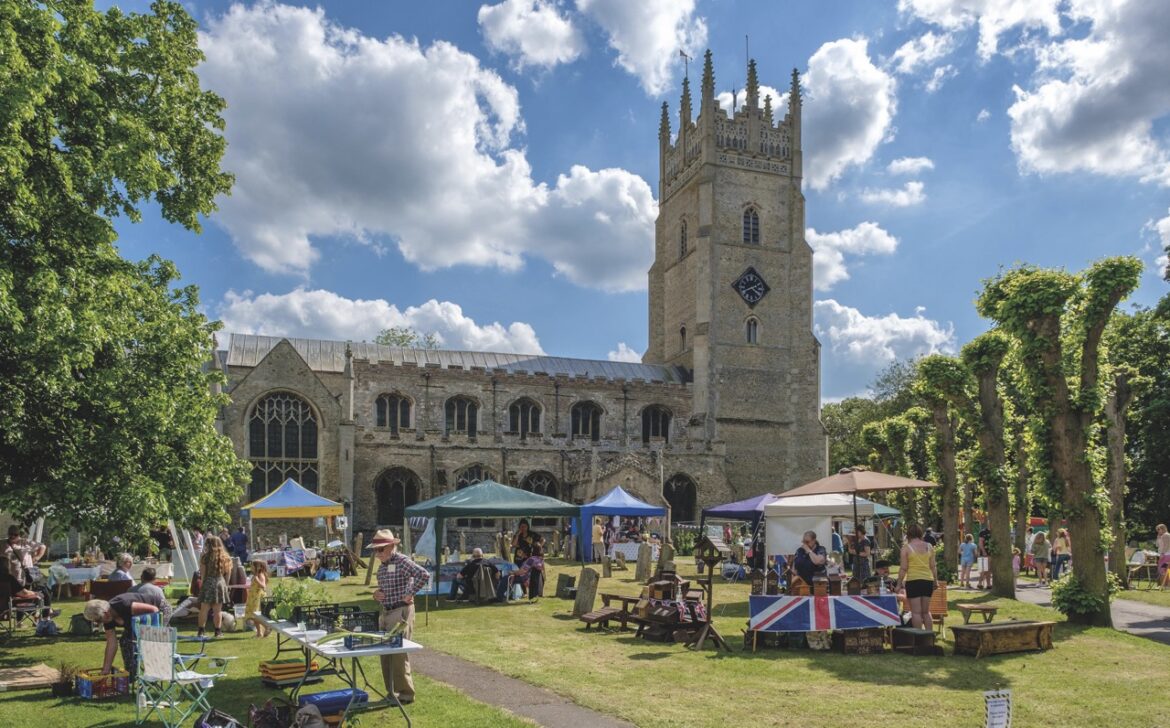 Umbrellas and gazebo set up in front of a church with a steeple