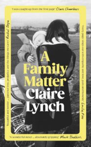 A black-and-white book cover showing a person facing away from a camera holding a small child. The book is bordered in yellow and is titled A Family Matter