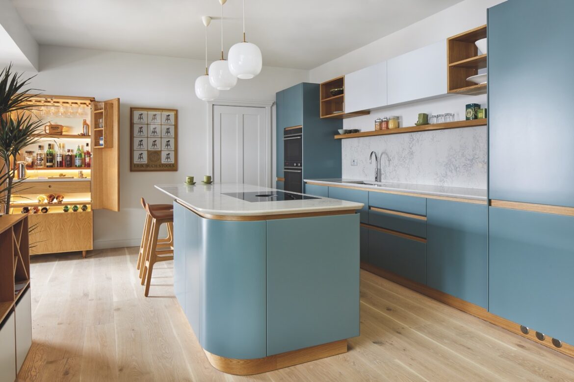 The interior of a modern kitchen with a blue island and cabinets