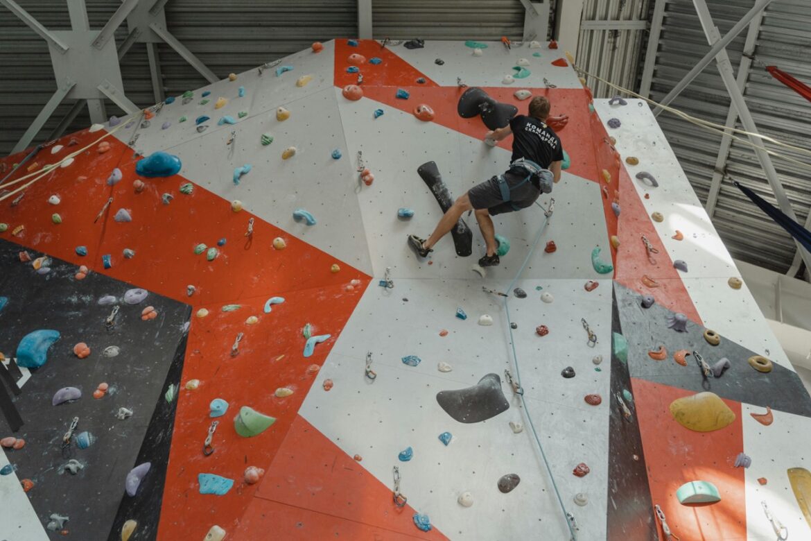 A man climbing up an inside climbing wall