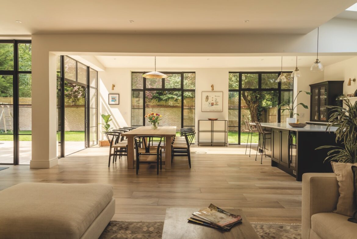 A kitchen-diner from The Burgess Group with large windows, a big table and a kitchen island