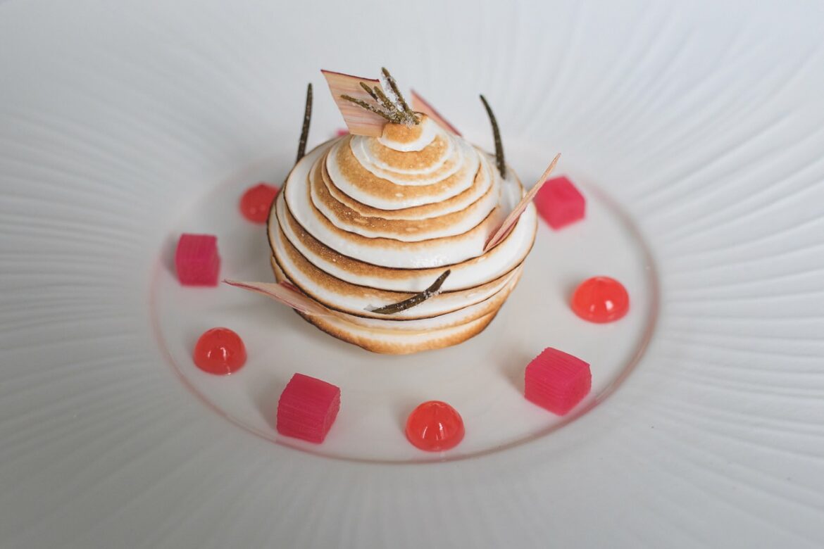 A dessert surrounded by red jelly on a round plate