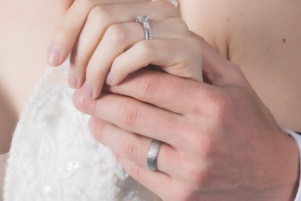Weddings 2025 – 164 Large A bride and groom holding hands, showing their Baker Brothers wedding rings