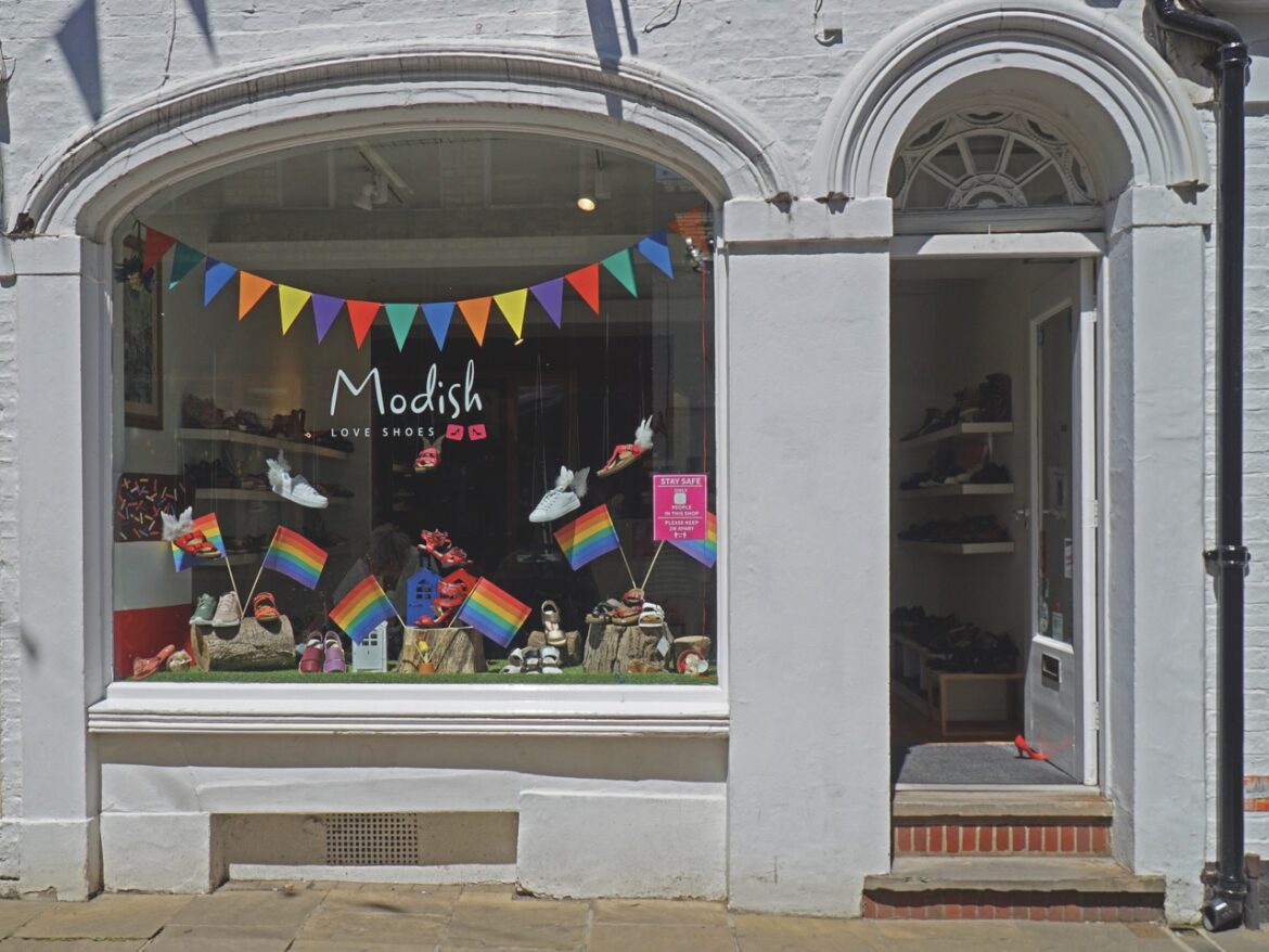 The exterior of a shoe shop in Cambridge with rainbow flags and bunting in the window