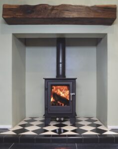 A fireplace area with a black wood burner on tiled floor