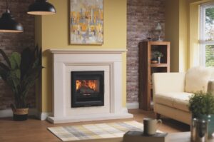 A living room with yellow walls and burnings and a fireplace in the centre 