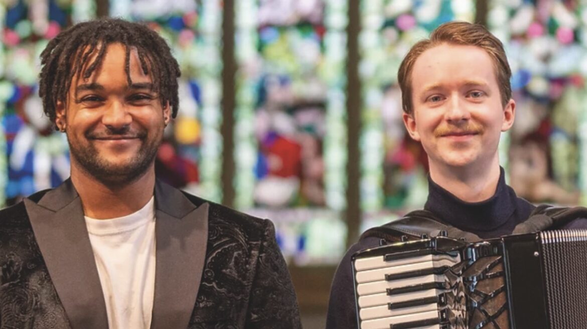 Two men in suits. One holds a trumpet while the other holds an accordion