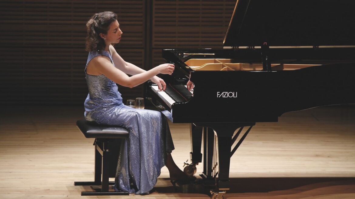 A woman in a gown playing a grand piano