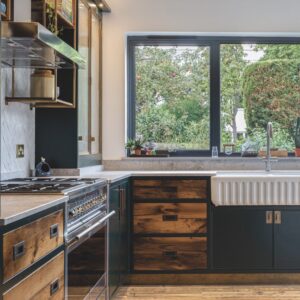A modern kitchen with a large window looking out to a garden