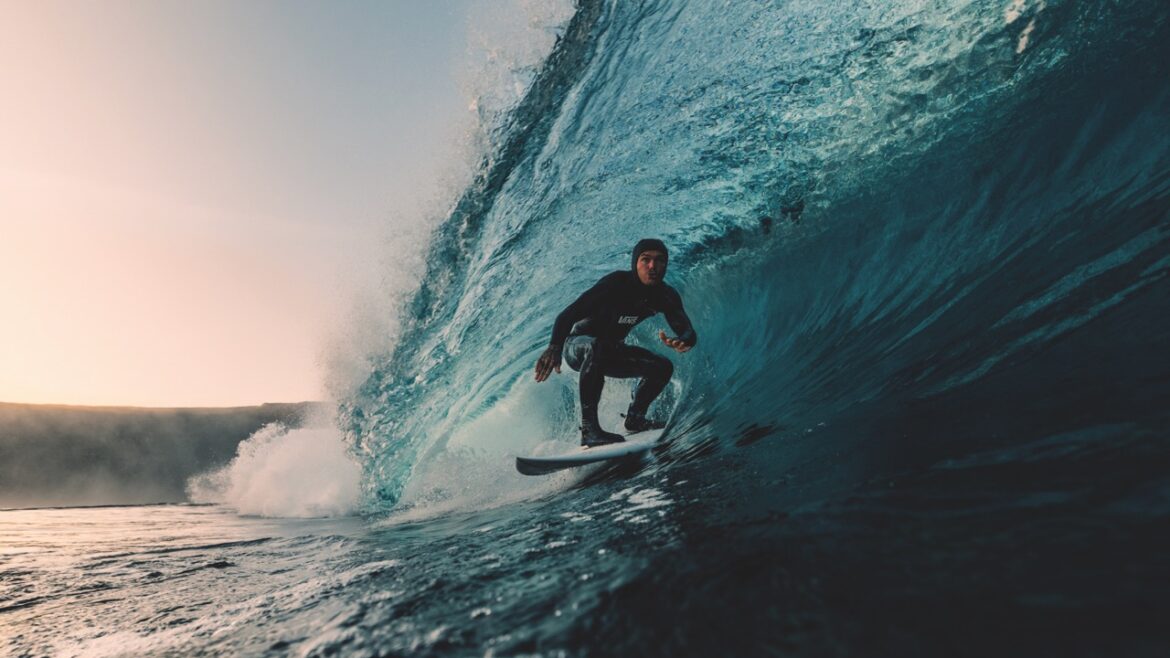 A person on a surfboard in the curve of wave