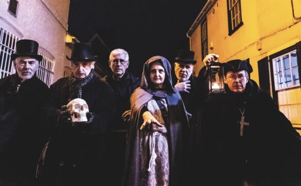 Actors in ghostly costumes, standing in a street