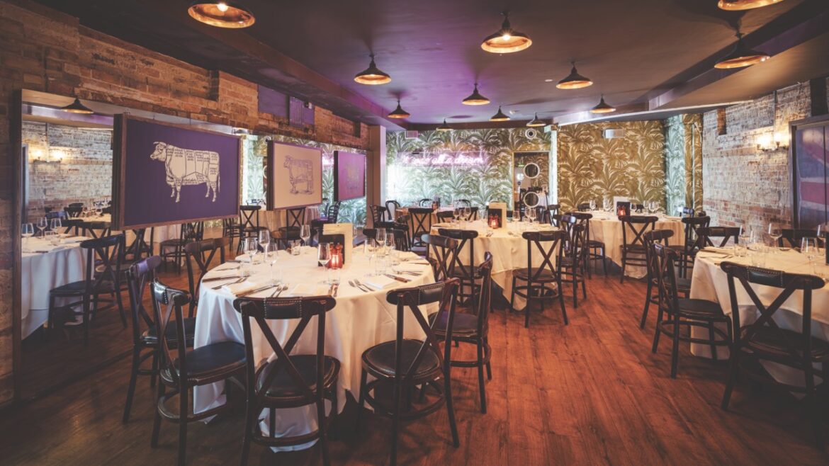 The interior of a decorated restaurant with round tables and low lighting