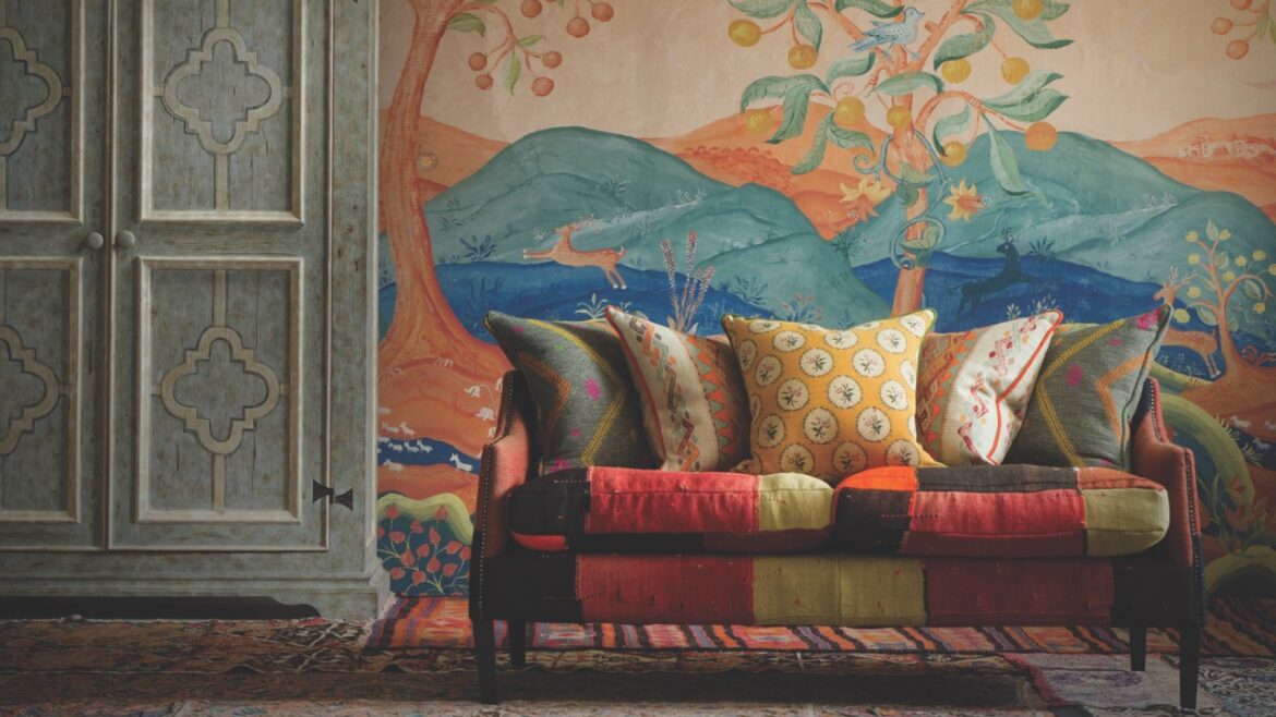 A living room with a painted mural on the wall and a bright sofa near a grey cupboard