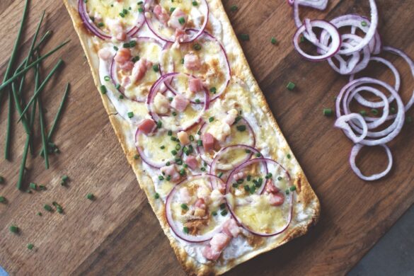 Amelie brings the Alsace to the home Top view of a baguette with cheese and vegetables on top, sitting on a wooden table