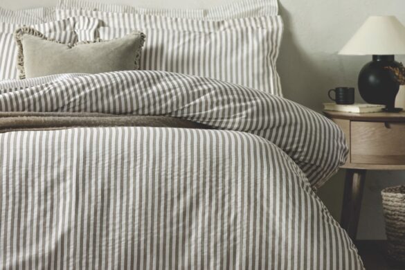 A bed with thick blue and white striped bedding