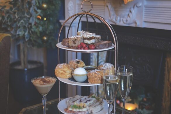 An afternoon tower surrounded by drinks and placed in front of a festive fireplace