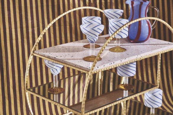 Why not try a chic bar cart with some decorative accessories from Oliver Bonas A round bar cart with blue and white glasses on