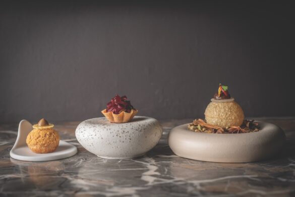 A line of three stone plates with desserts placed on them
