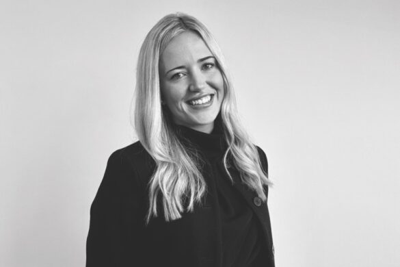 A black and white image of a smiling woman in a black jumper
