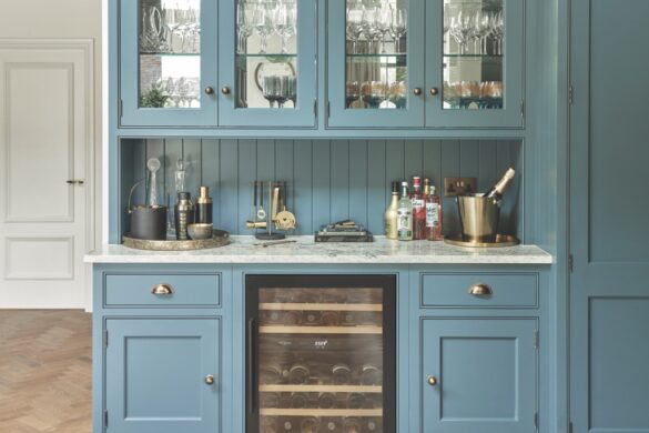 A Tom Howley dual-zone wine cooler and an ice maker from are also great as barware A modern kitchen area with blue cupboards, a countertop for a home bar and a wine cooler