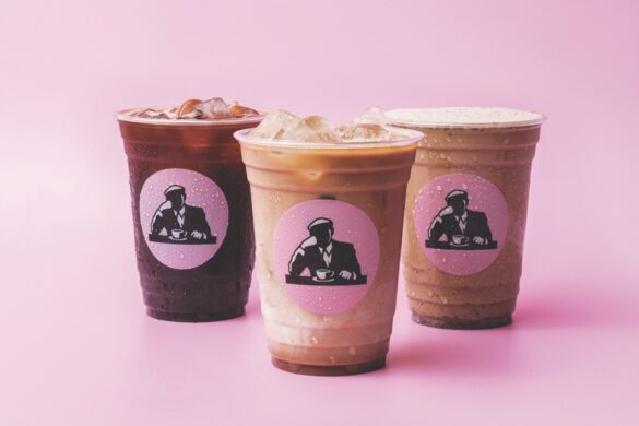 Three coffee cups from Joe & The Juice, against a pink background