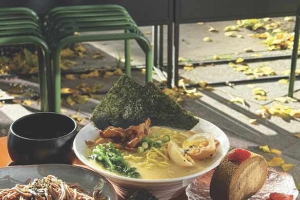 Plates of food including mains and desserts, placed on a tray on a table outside