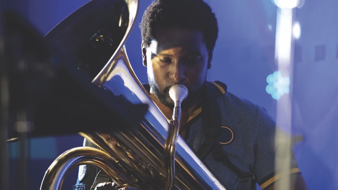 A man playing a trombone in blue lighting