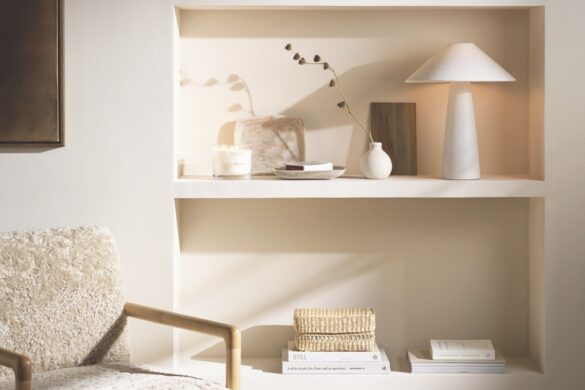 A modern living room with a bookshelf built into a wall next to a comfy chair