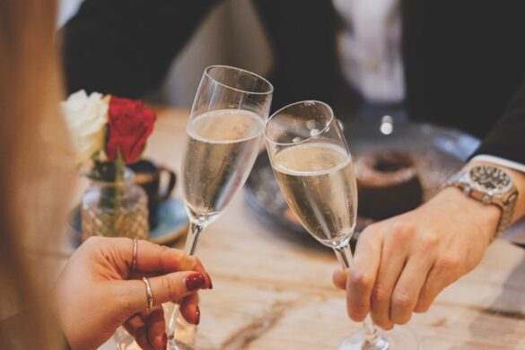 A couple tapping their wine glasses filled with wine
