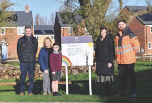 A group in front of a sign, standing outside