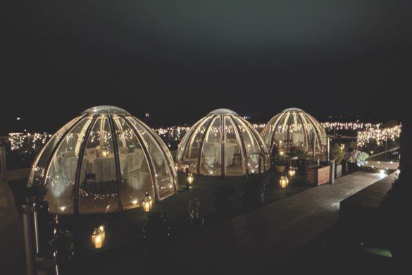 A line of igloo domes looking at a skyline at night