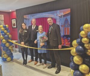 A group standing behind a golden tape