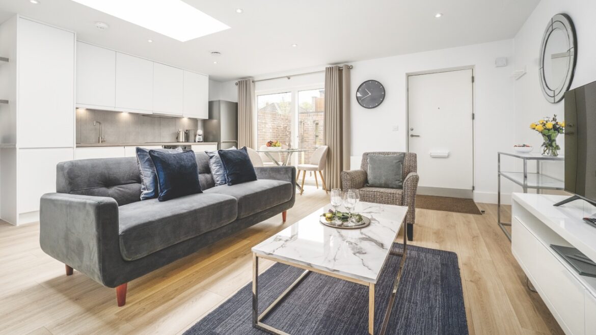 A modern living room with grey couches and features and white walls